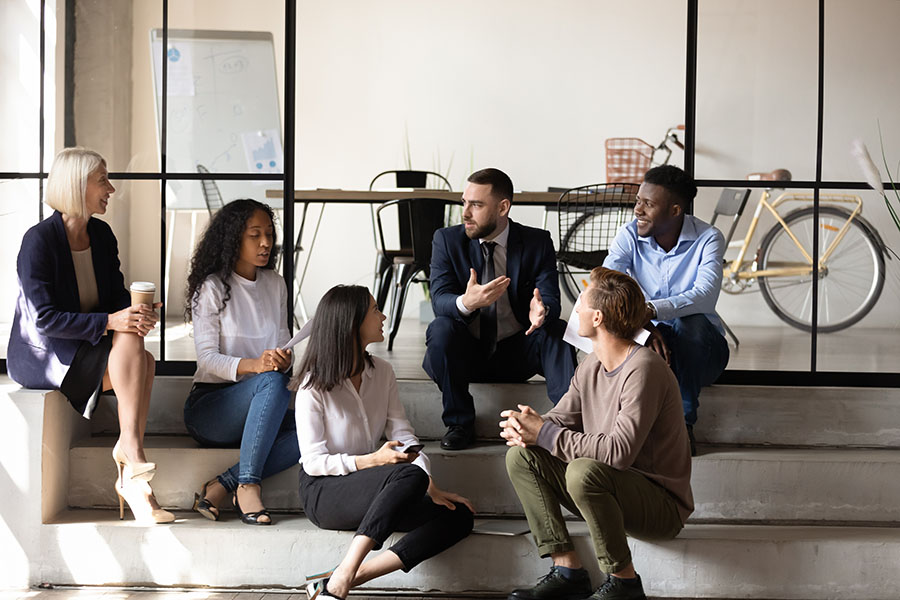 Employee Benefits - Group of Coworkers Chatting on Stairs